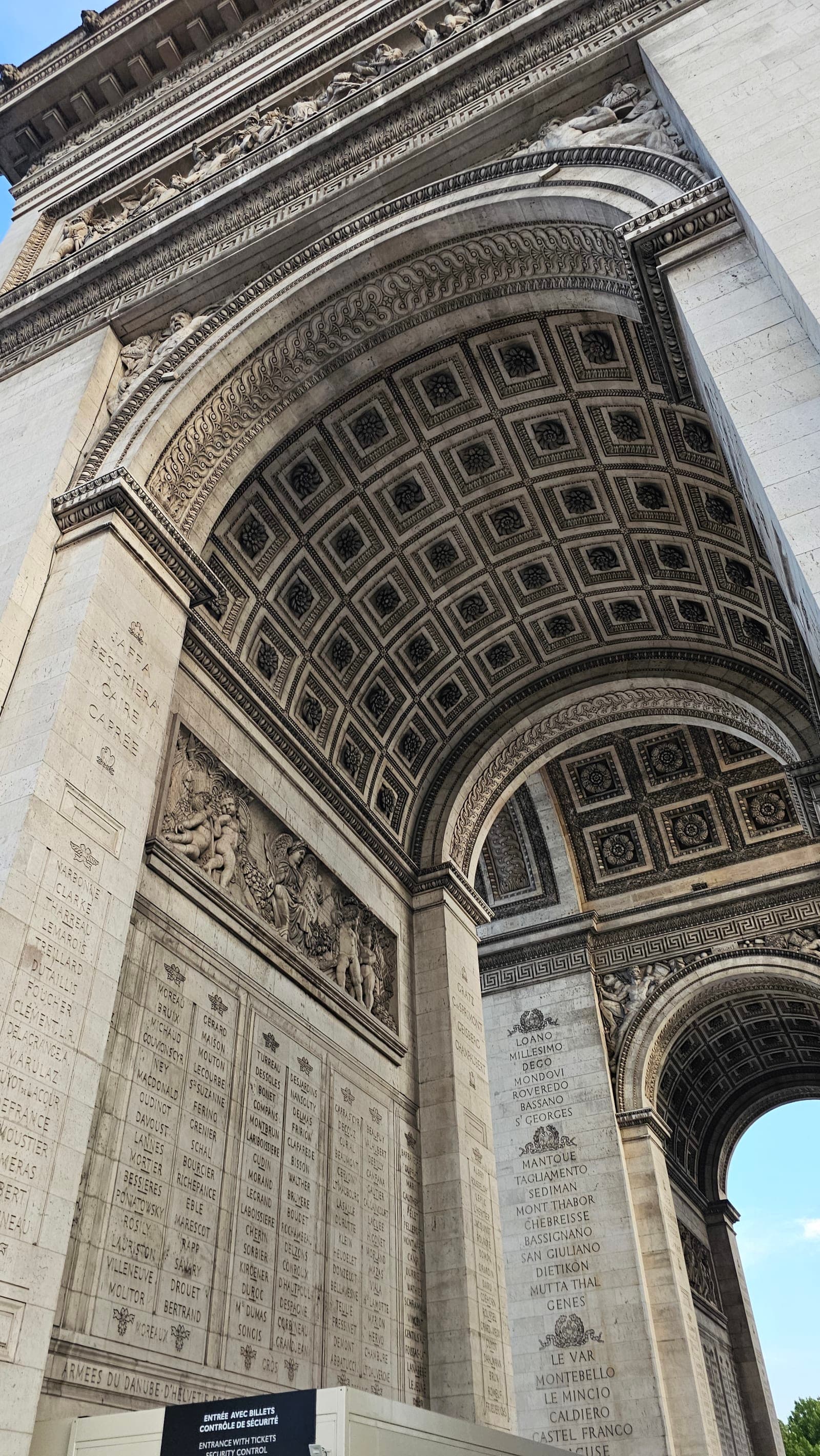 Looking up at the ornate carved ceiling and engravings of the Arc de Triomphe in Paris, France — photo by Abdullah Al-Marweai